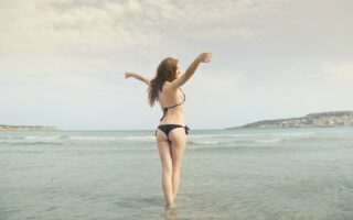woman in black bikini standing on shore