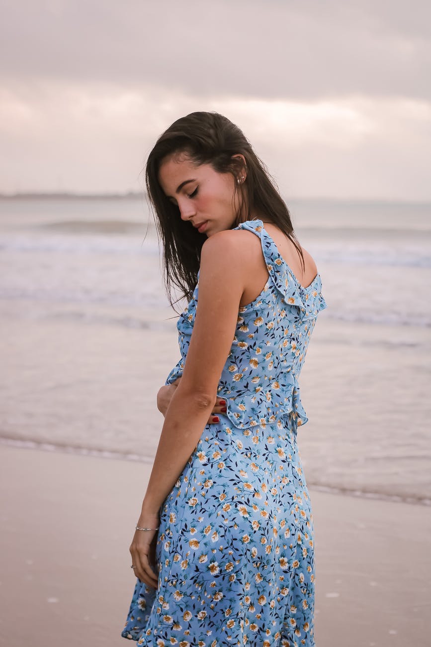 dreamy tourist in sundress on ocean beach