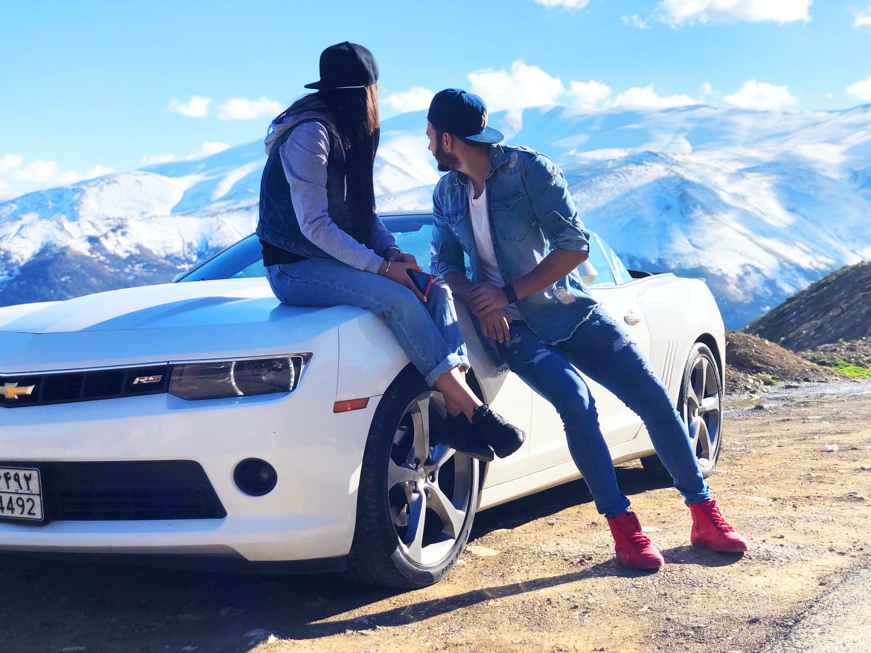 couple near white chevrolet coupe