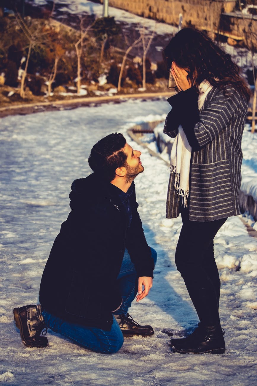 man kneeling in front of woman