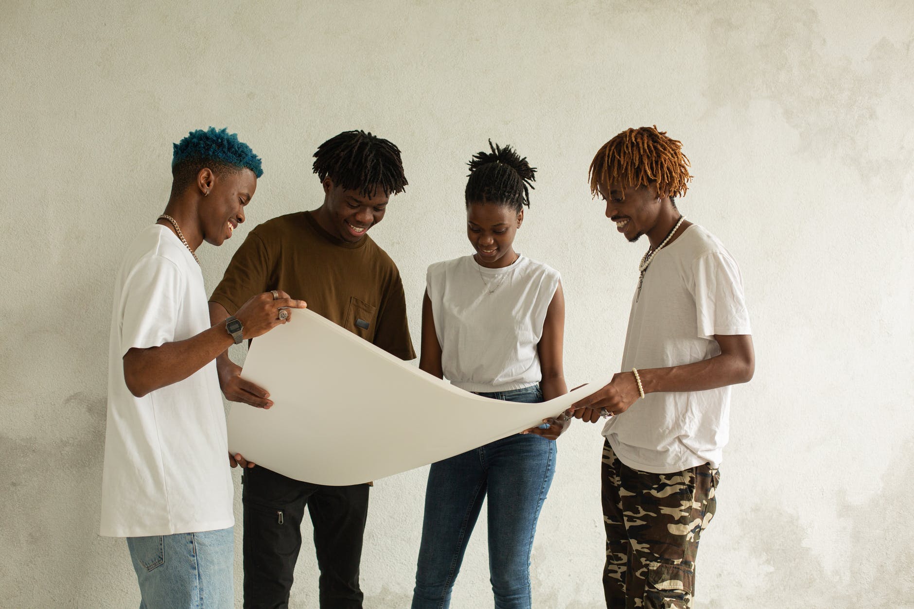 cheerful african american team of students holding drawing paper together